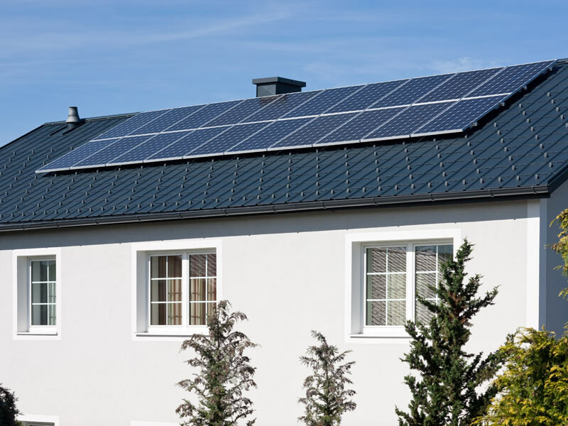 Fotovoltaïsche installatie die met het PREFA montagesysteem voor zonnepanelen op antracietkleurige PREFA dakpannen is geïnstalleerd