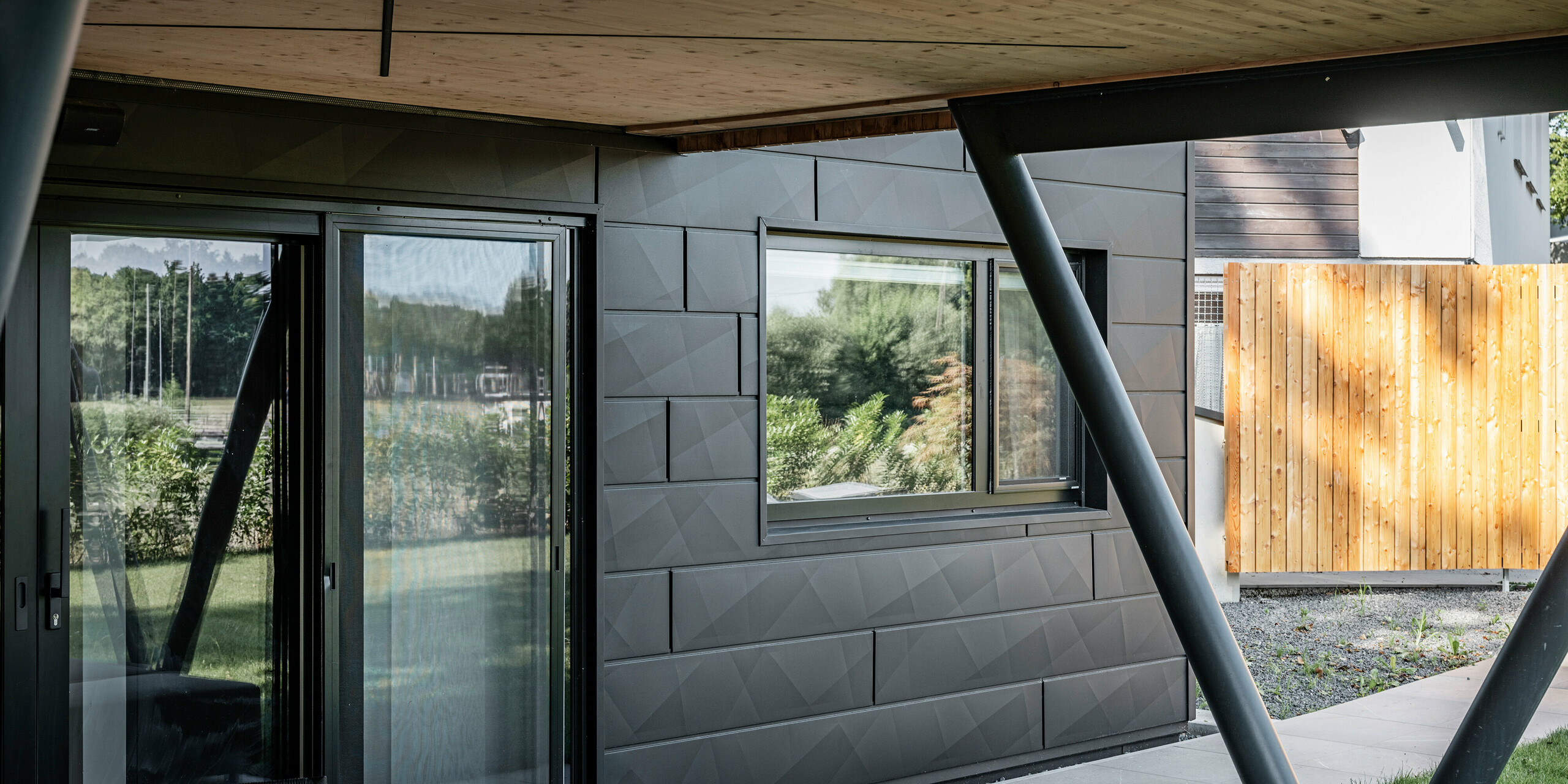Fenster und Türe des Chalet 5 in St. Martin am Innkreis mit Fassadenverkleidung PREFA Siding.X in P.10 Anthrazit