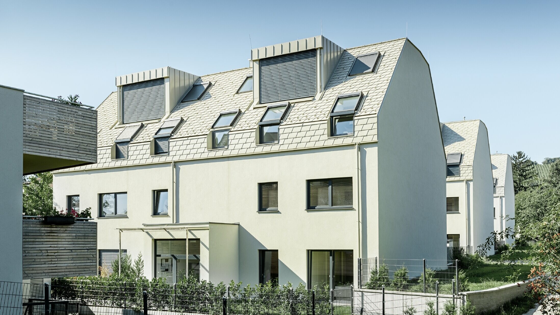 Nieuw woongebouw met groot aluminium dakvlak en talrijke dakvensters