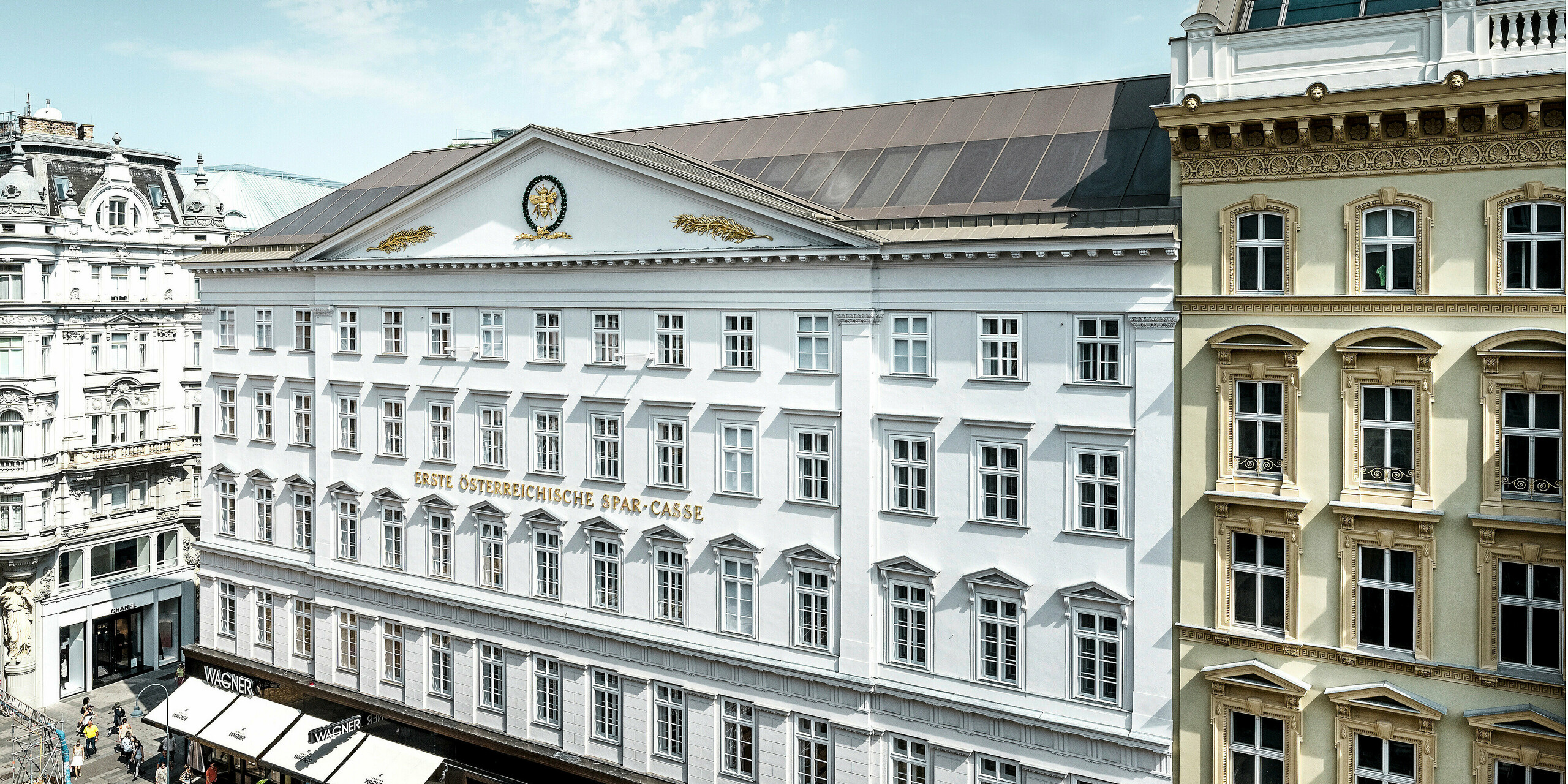 Vue de la partie latérale de l'hôtel, avec sa façade historique et son toit en aluminium de couleur bronze.