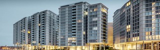 Vorderansicht der Belvedere Apartments am Abend. Die PREFA Profilwelle wurde mit Glas und Keramikelementen kombiniert