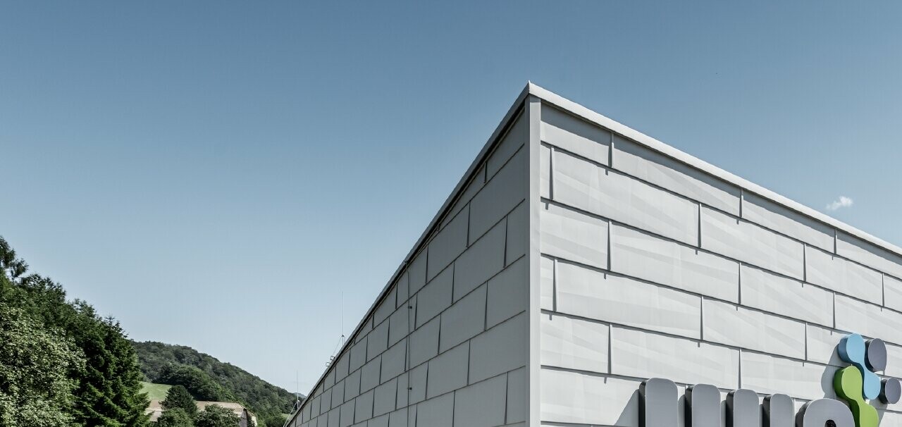 Bâtiment de société moderne à Ybbsitz avec toit plat et façade en aluminium ; la façade a été habillée avec les panneaux de façade FX.12 PREFA couleur blanc PREFA.