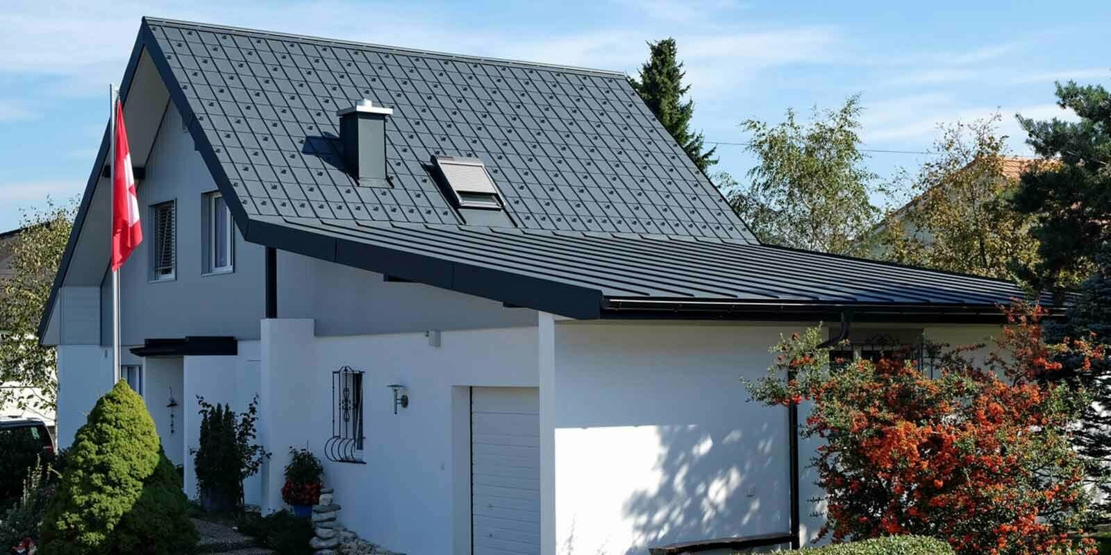 Maison avec garage après la rénovation de toiture à l’aide de tuiles PREFA couleur anthracite