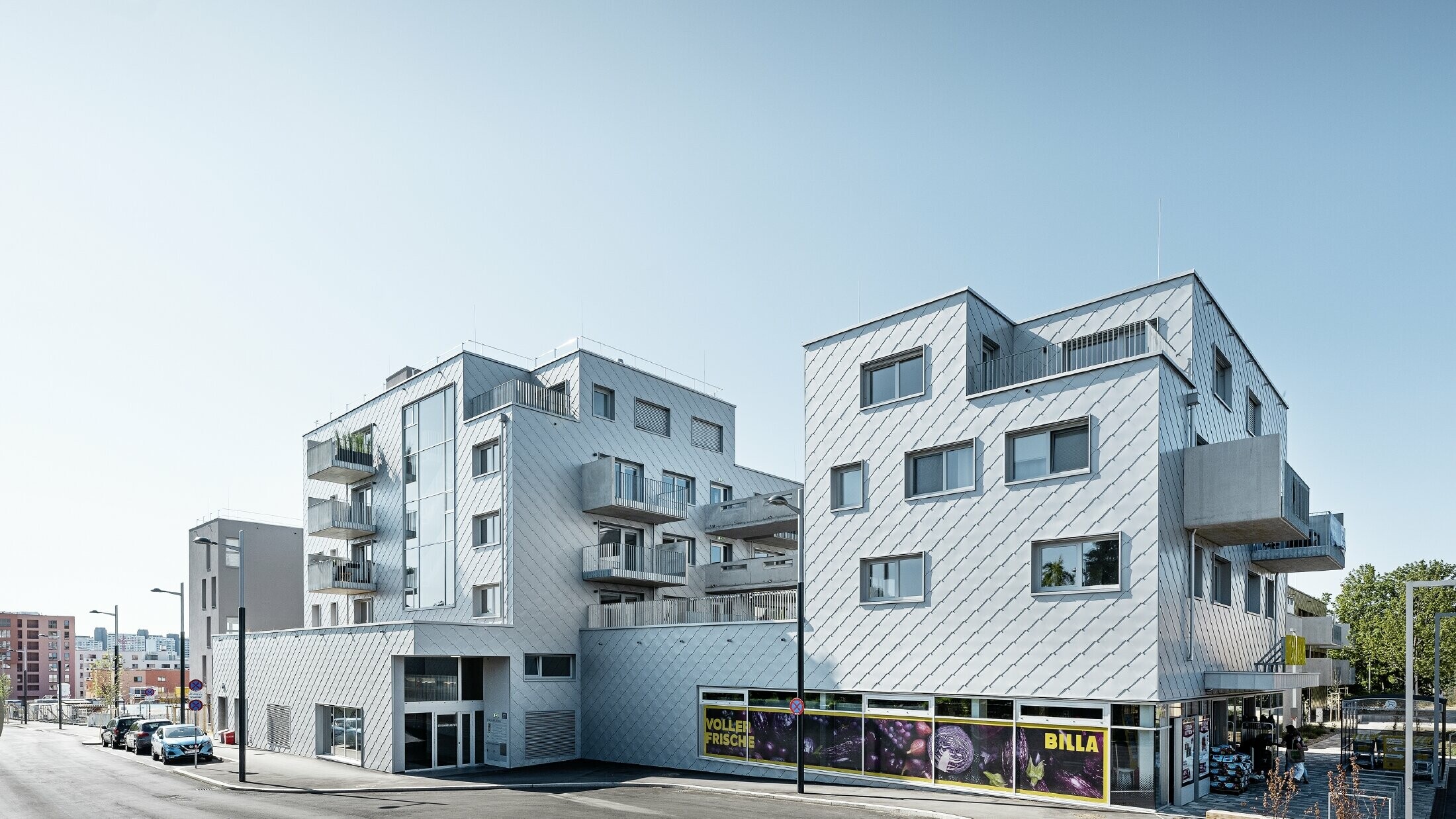 Complexe résidentiel à toit plat recouvert de losanges de façade 44 x 44 PREFA en argent métallisé.