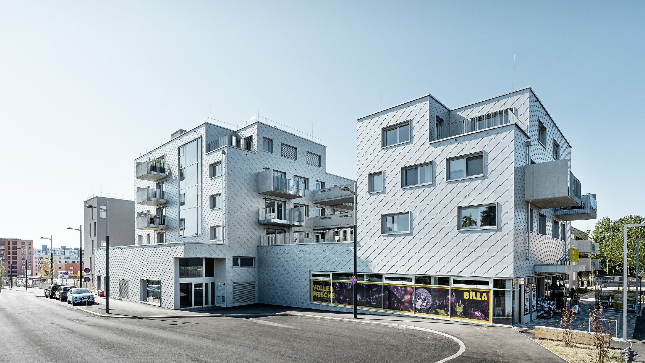 [Translate to Deutsch:] Wohnhausanlagen mit Flachdach und Rautenverkleidung an der Fassade mit der PREFA Wandraute 44 × 44 in Silbermetallic