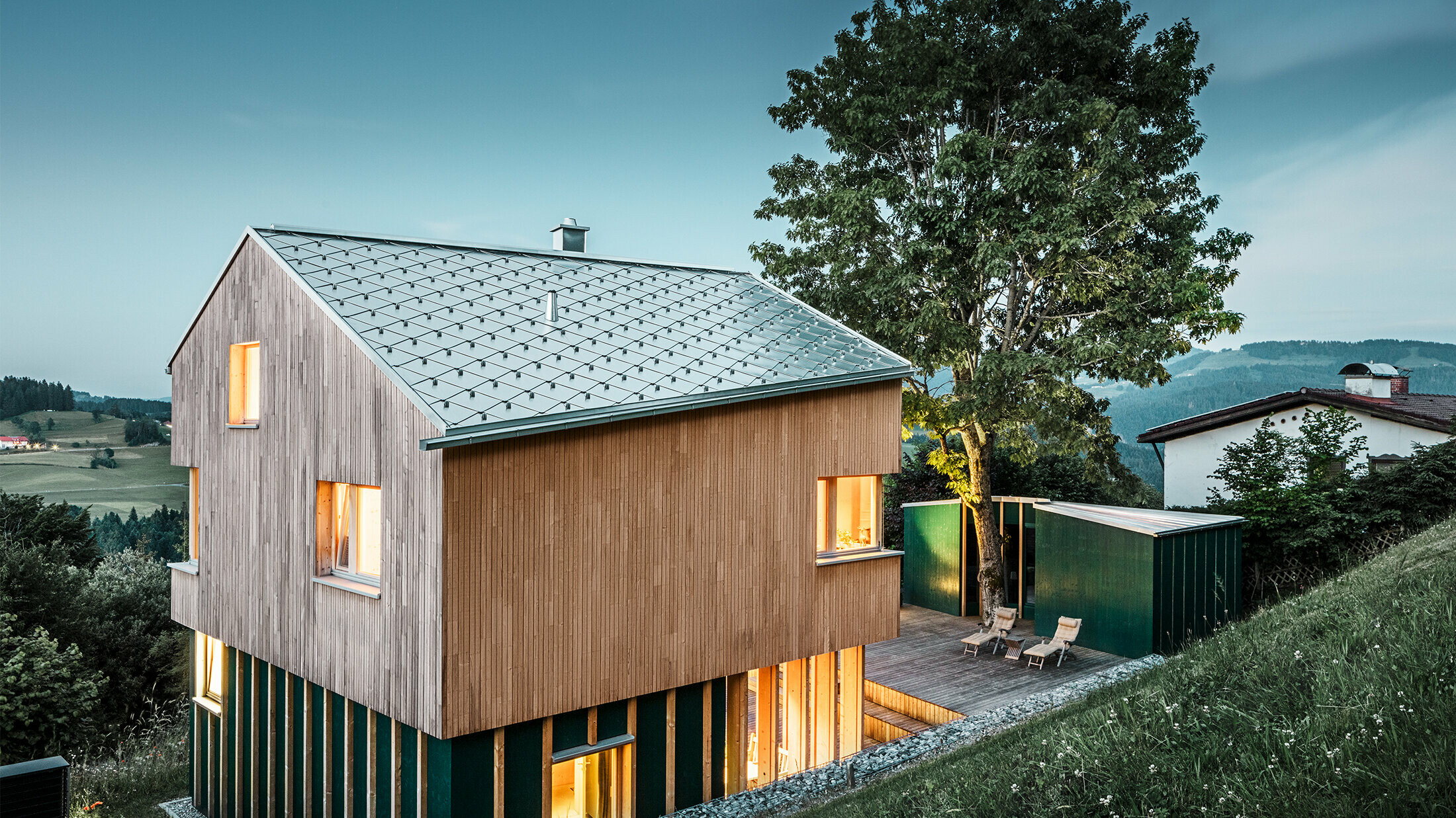 Nieuw gebouwde eengezinswoning met houten gevel en een naturel- blank PREFA-dakbedekking in ruitvorm