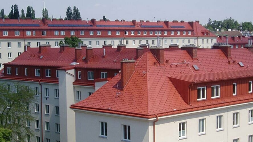Foto van de woonhuizen aan het Hugo Breitner Hof in Wenen. De daken zijn met de PREFA-dakschindel in baksteenrood bedekt.