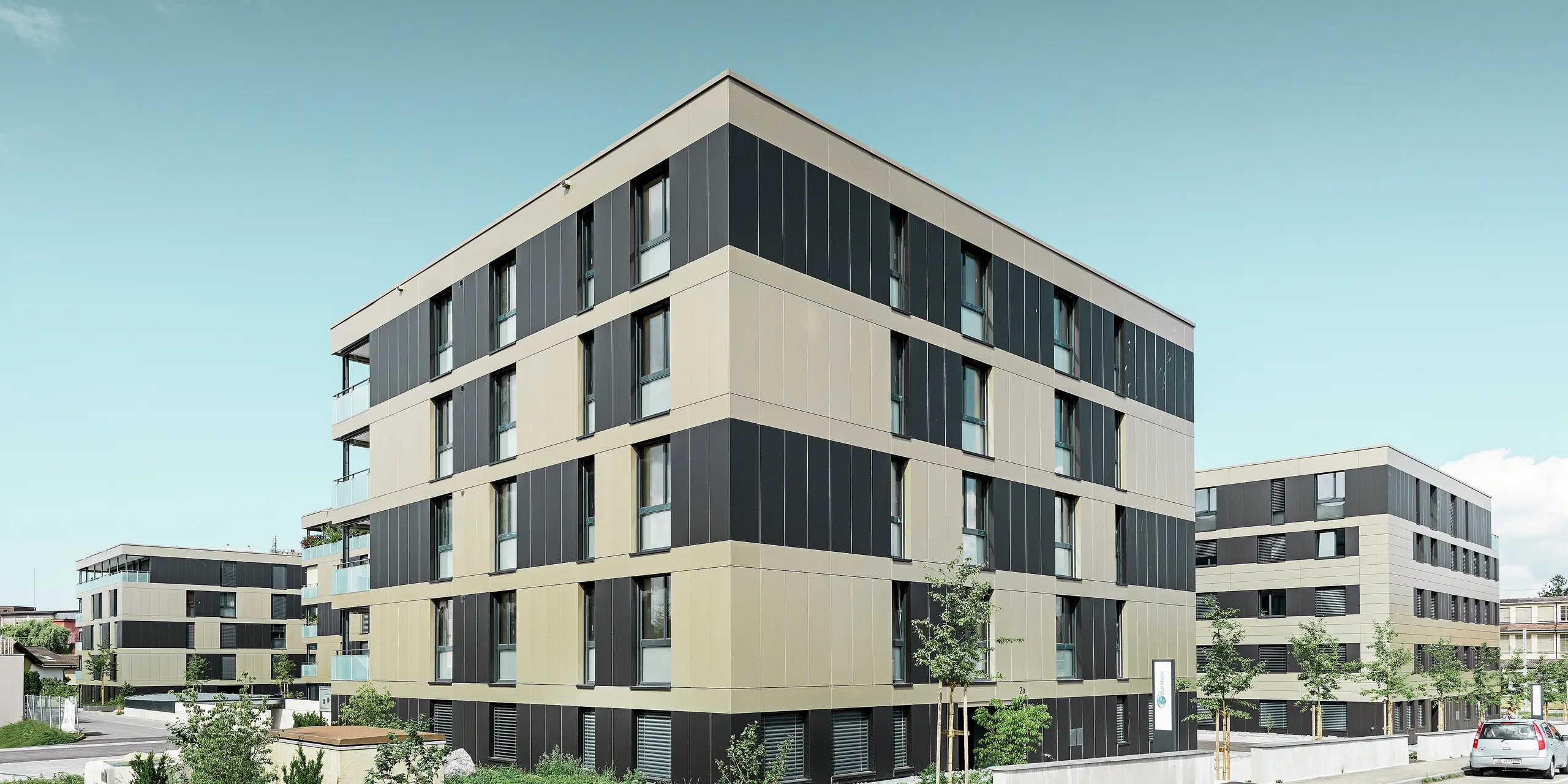 Kubusvormig woongebouw met aluminiumgevel in brons en zwartgrijze elementen