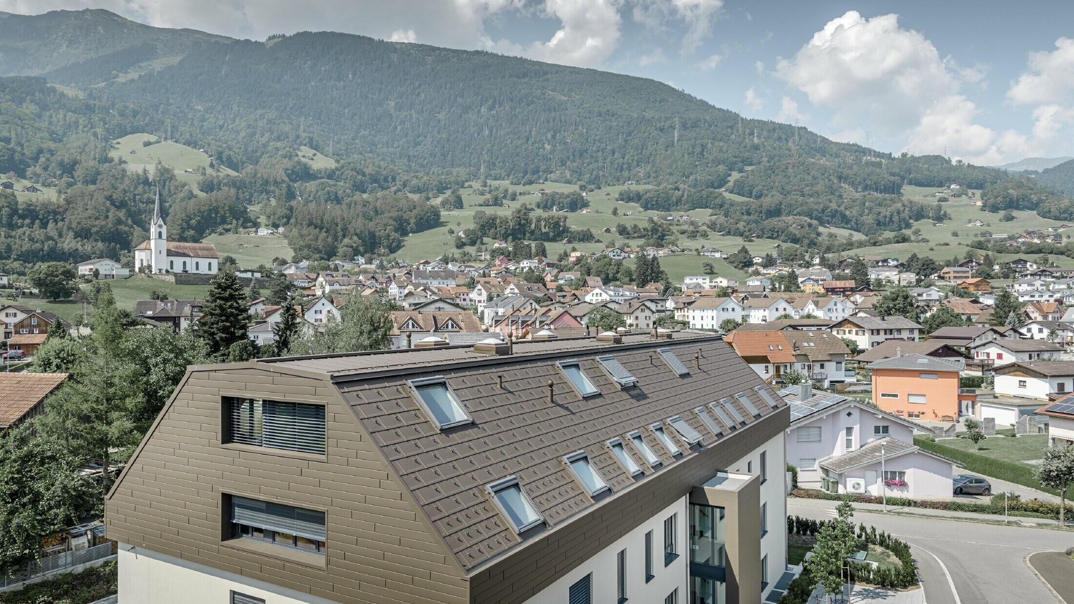 Dachgeschoßausbau des Wohnhauses in Wangs mit braunen Alu-Paneelen von PREFA für Dach und Fassade.