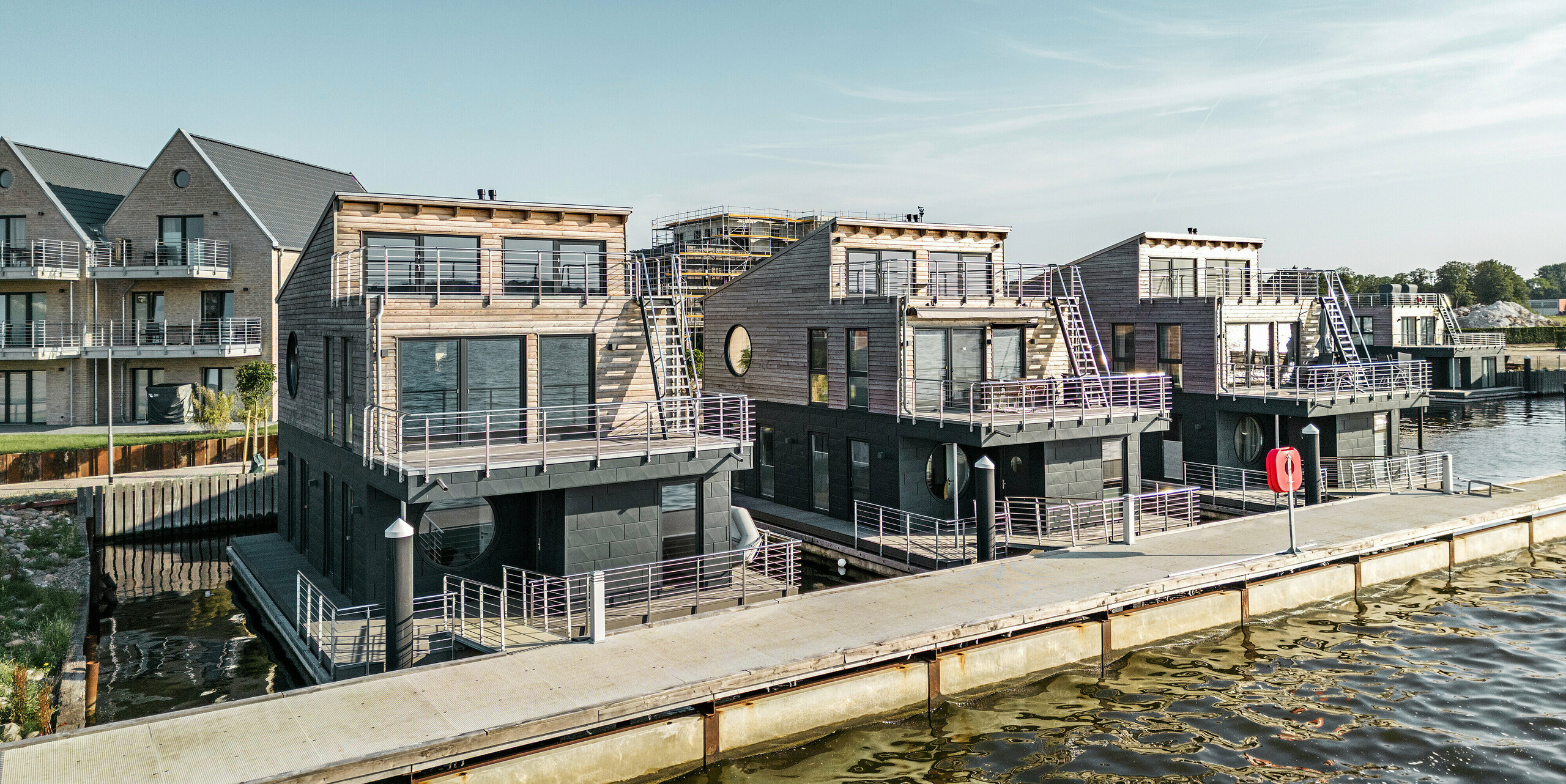 La façade en aluminium Siding.X PREFA entoure onze maisons flottantes dans le port pionnier du Schleswig.