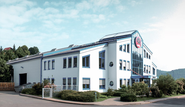 PREFA Firmengebäude mit blauen Fenstern und weißer Fassade in Wasungen, Deutschland.