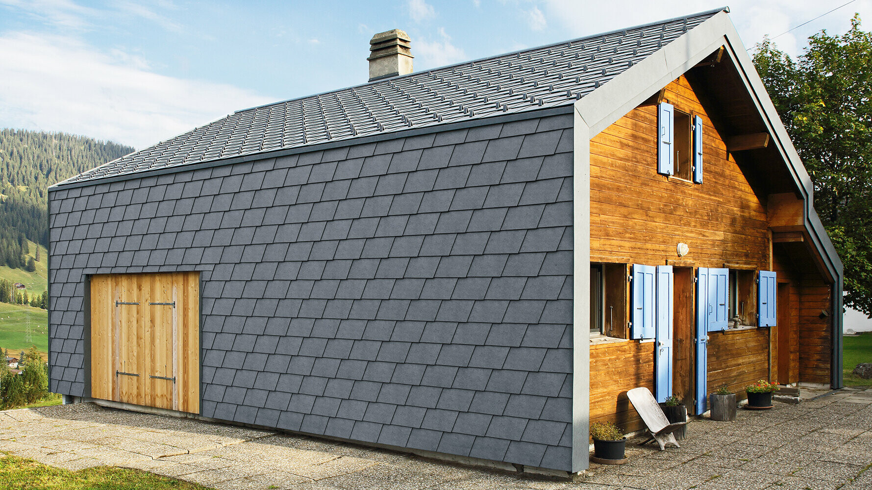 Moderne eengezinswoning bekleed met PREFA gevelschindels in antraciet en houten elementen.