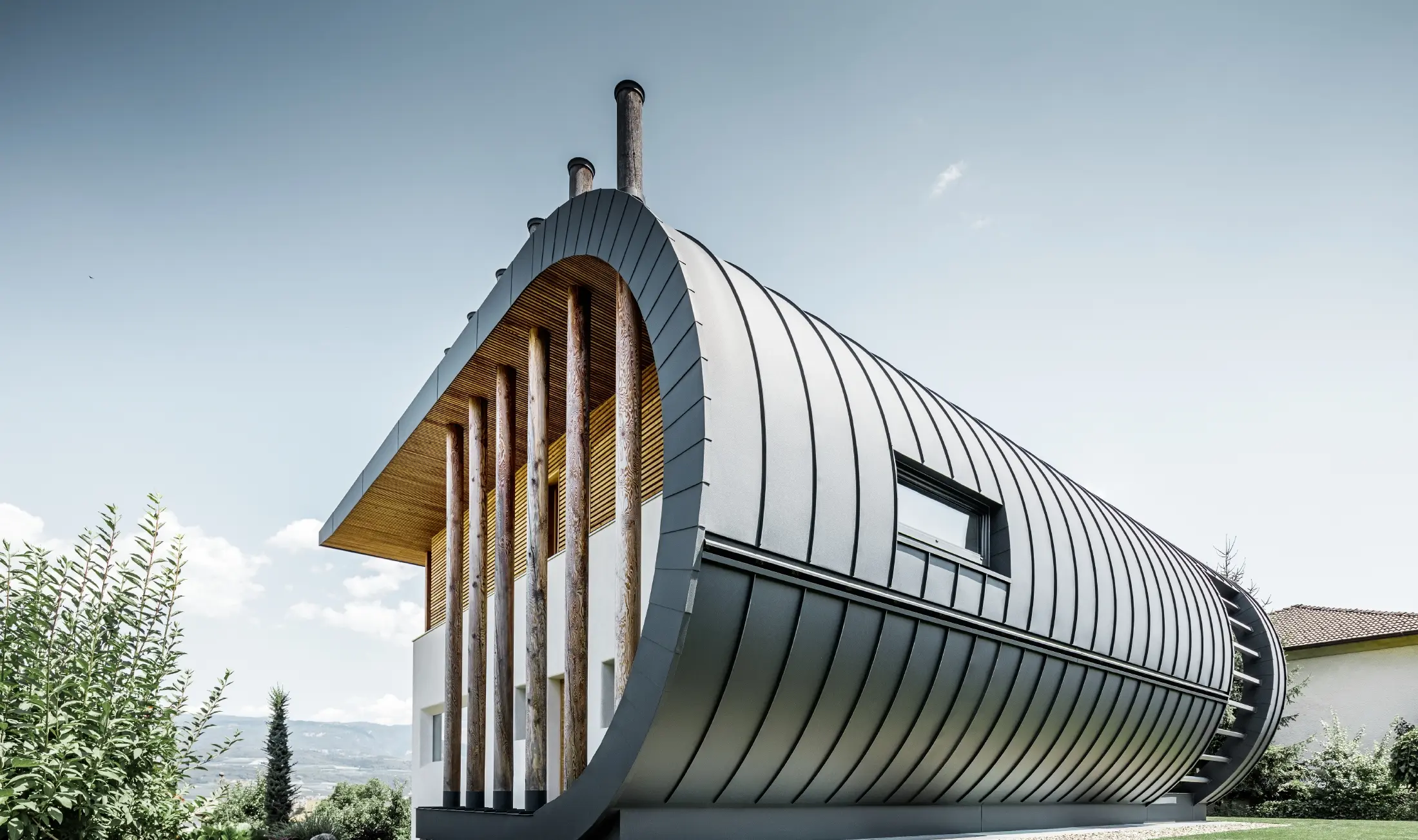 Gebogen gevel van de eengezinswoning Casa Giovannini bekleed met aluminium van PREFA - Prefalz in P.10 antraciet.