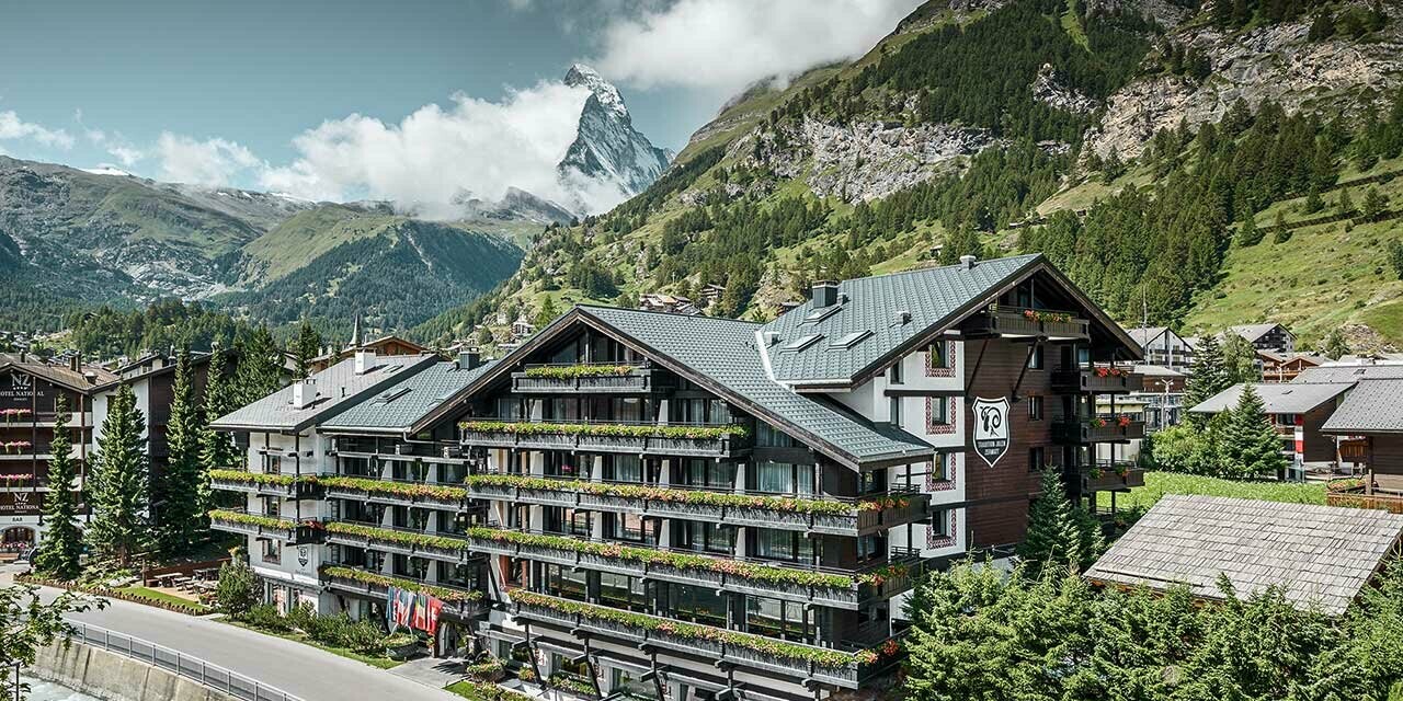 Hotel Alpenhof in Zermatt (Zwitserland) met de Matterhorn op de achtergrond, een gevel en balkons in donker hout en een antracietkleurig aluminiumdak van PREFA
