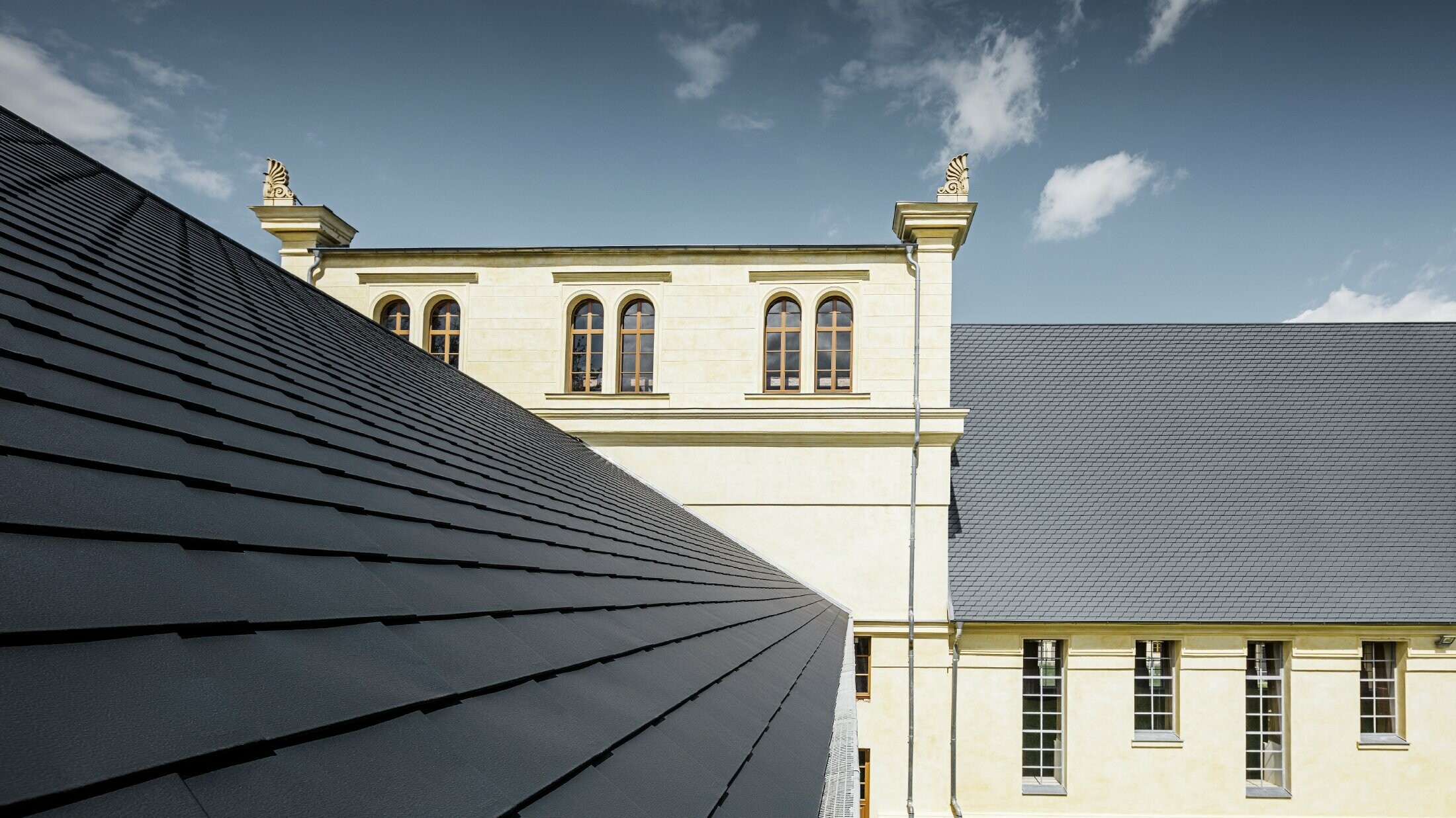 Vue détaillée du nouveau toit des écuries de Basedow ; le toit a été rénové à l'aide de bardeaux de toiture PREFA couleur anthracite.