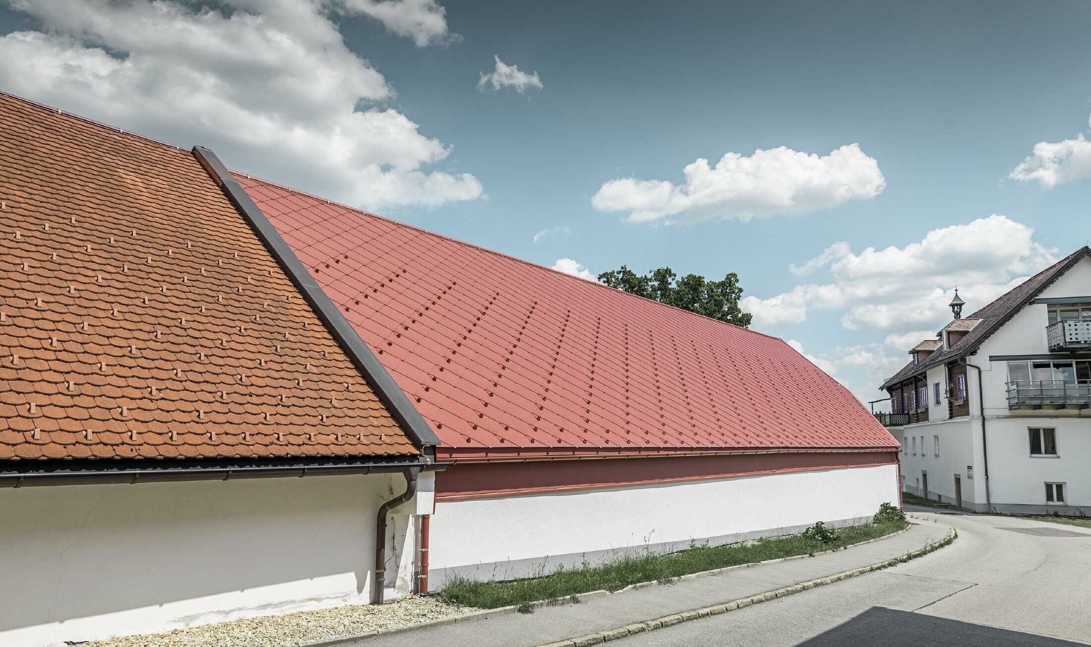 Buitenopname van de Kerzenwelt in Schlägl; het dak is gedekt met de grote aluminium losange 44x44 van PREFA in oxiderood.