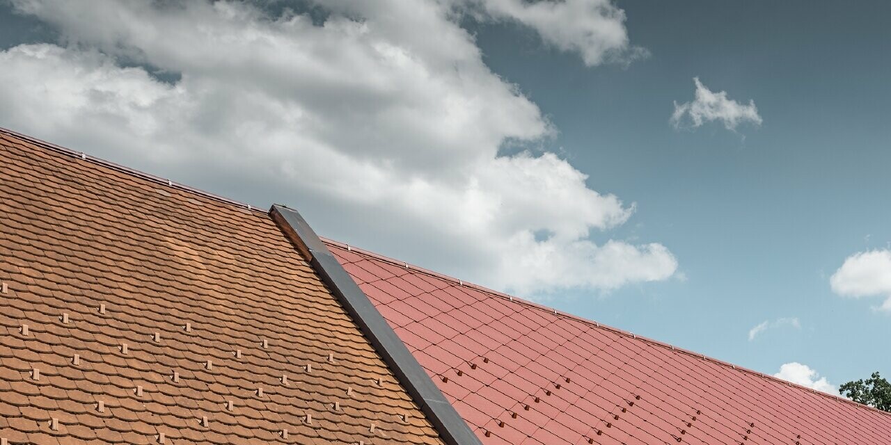 Prise de vue extérieure du Kerzenwelt de Schlägl ; la toiture a été recouverte de losanges en alu grand format 44 x 44 PREFA couleur rouge oxyde.