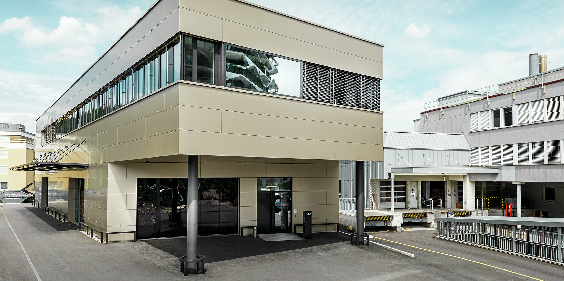 Moderne aanbouw met werkplaats en bureau afgewerkt met bronskleurige aluminium composietplaten van PREFA