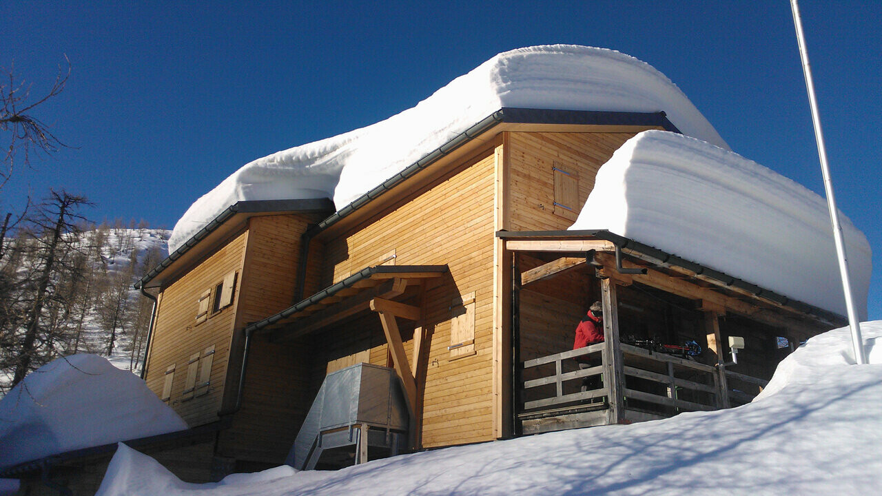 Berghut Capanna Buffalora met meerdere centimeters sneeuw op het dak 