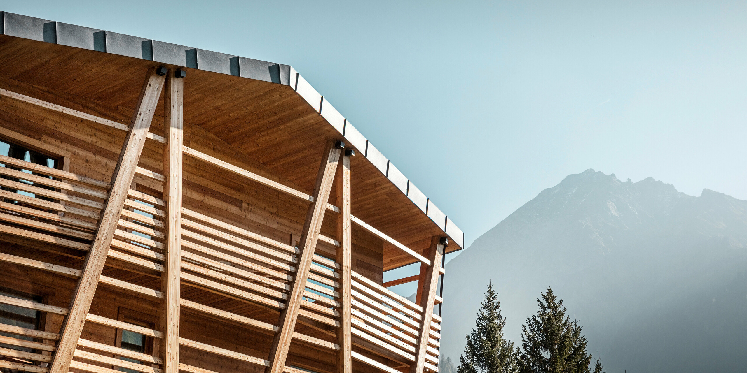 Luxus-Öko-Hotel Au Charmant Petit Lac in Champluc mit einem PREFALZ-Dach in P.10 Steingrau und einer Holzfassade..