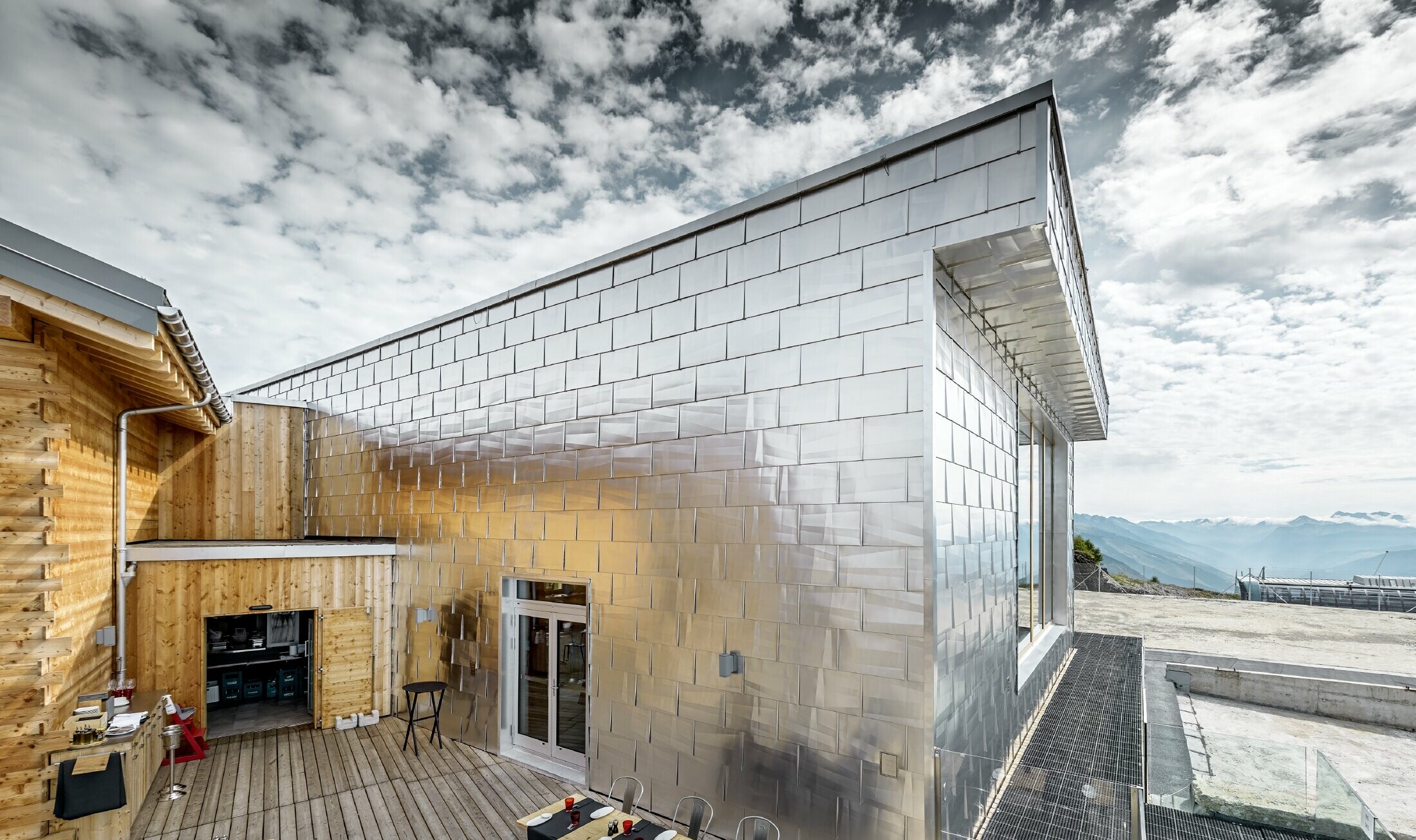 Glanzende aluminium gevel in aluminium naturel blank van de Cry D'Er Club d'Altitude in Zwitserland; de gevel reflecteert het schitterende 360° panorama.