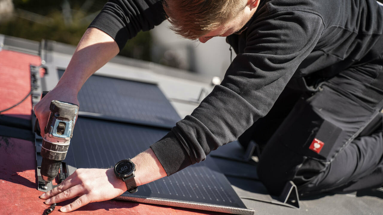 Ein PREFA Mitarbeiter bei der Verlegung der Solardachplatte.