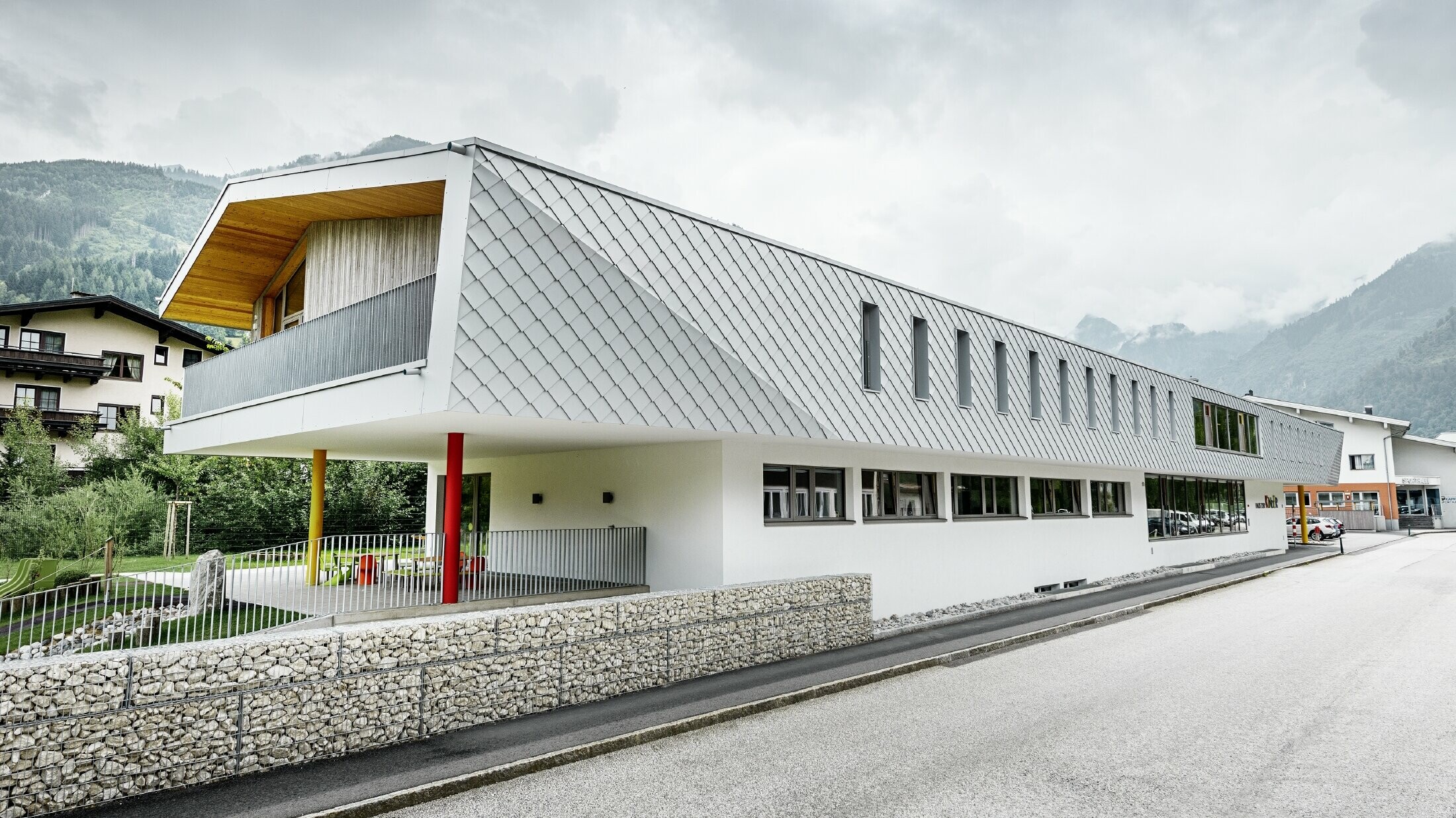 Nieuwe kleuterschool in Kaprun (Oostenrijk) met moderne aluminiumgevel bedekt met PREFA-gevellosanges in prefawit