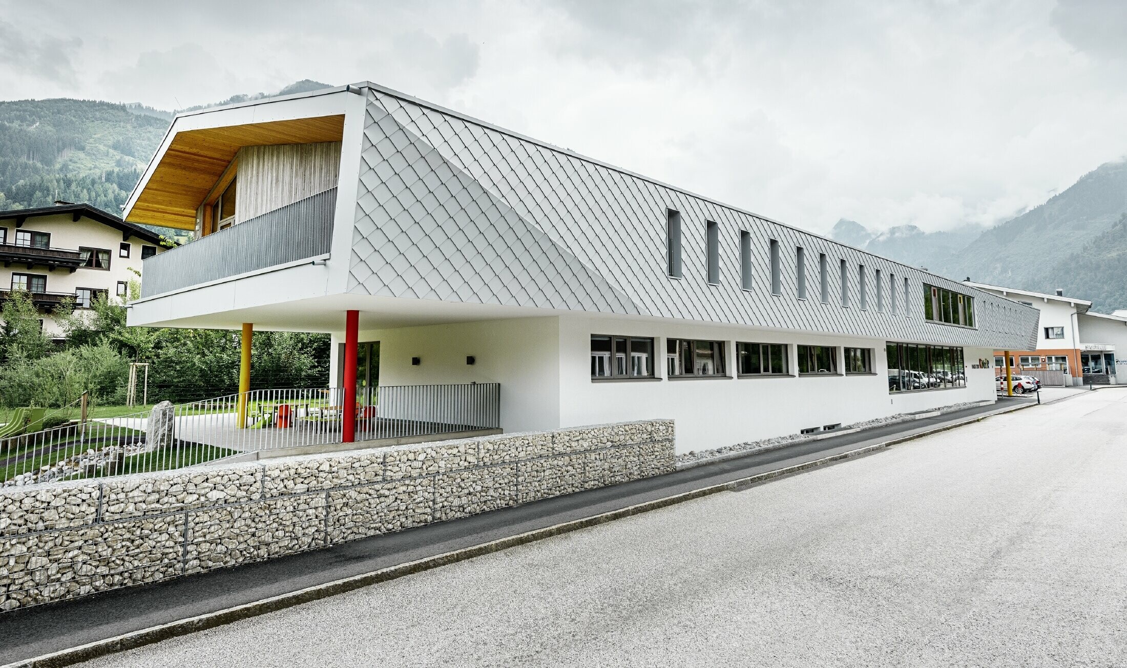 neu gebauter Kindergarten in Kaprun mit einer modernen Aluminium Fassade mit der PREFA Wandraute in prefaweiss