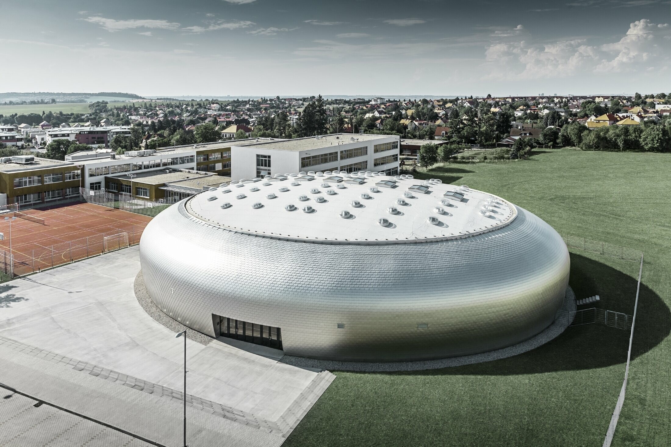 Vue aérienne du gymnase en République tchèque avec le losange de façade PREFA en alu brillant naturel.