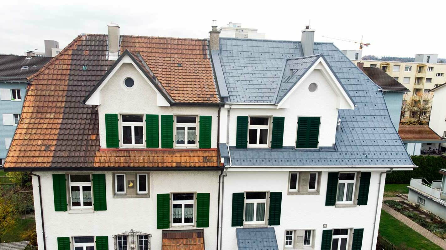 Twee-onder-een kapwoning in Zwitserland; het linker gebouwdeel werd nog niet gerenoveerd en is nog gedekt met bevuilde dakpannen. Het rechter gebouwdeel werd gedekt met de PREFA dakplaten in steengrijs.