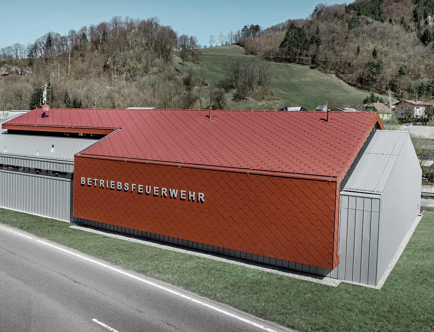 PREFA daklosange van 44 × 44 in oxiderood referentie De nieuwe brandweerkazerne van de bedrijfsbrandweer van PREFA en Neuman Aluminium werd bekleed met de nieuwe dak- en gevellosange van 44 × 44 in P.10 oxiderood, alsmede Prefalz in zilvermetallic.